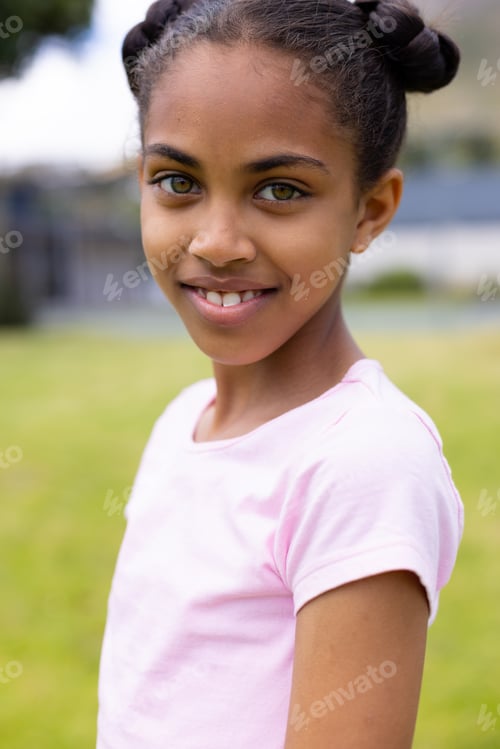 Preview: Portrait of happy african american schoolgirl looking at camera and smiling at school