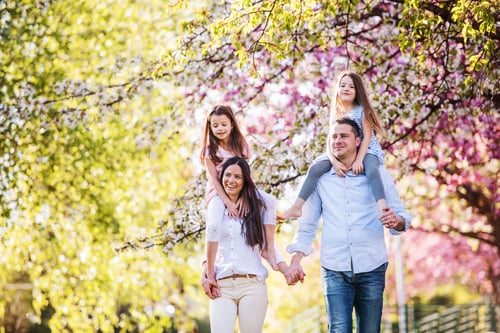 Preview: Young parents with small daugthers walking outside in spring nature