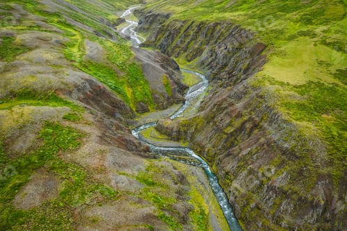 Preview: Drone view over green hills, canyon and small river in Iceland, summertime