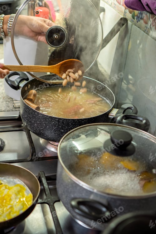 Preview: Person adding white beans into boiling pot
