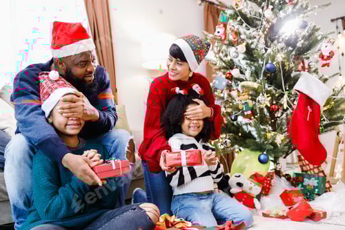 Preview: African American family surprising with a gift on Christmas day. Merry Christmas.
