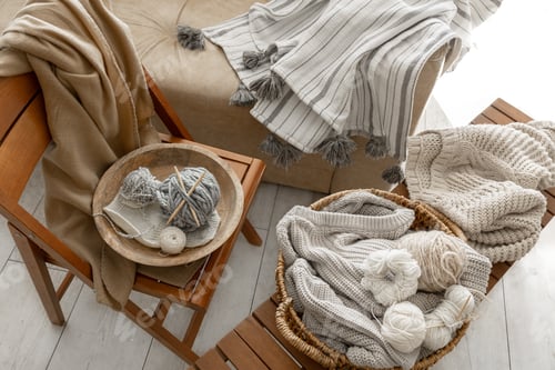 Preview: Basket with threads for knitting on a wooden bench in the interior of the room.