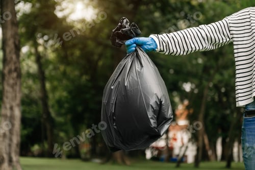 Preview: Hand holding garbage black bag putting in to trash to clean. Clearing, pollution, ecology