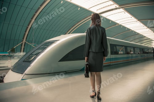 Preview: Business woman waiting for a train on railway platform, Shanghai, China