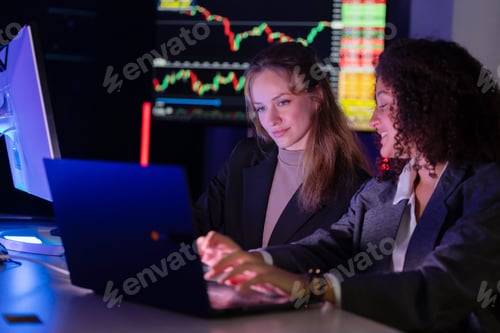 Preview: Colleagues discuss stock market trends in a modern office setting during evening hours