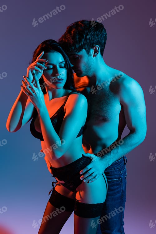 Preview: muscular man touching sexy woman in lingerie and stockings on purple
