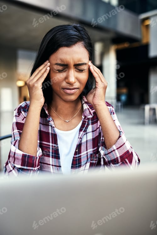 Preview: Cropped shot of a young female student experiencing a headache outside on campus