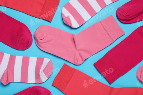 Preview: Different colorful socks on light blue background, flat lay