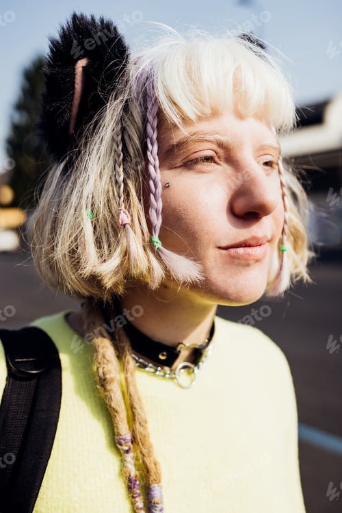 Preview: Gender fluid contemplative young woman outdoor looking over serious and confident