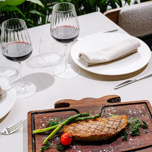 Preview: Tasty grilled steak with veggies and red wine in a restaurant
