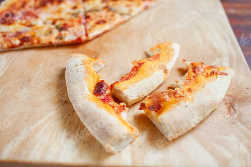 Preview: Pizza on a wooden tray. Dry crusts of the edge of the pizza