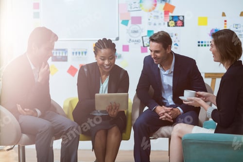 Preview: Businesswoman Discussing With Colleagues Over Digital Tablet In The Office