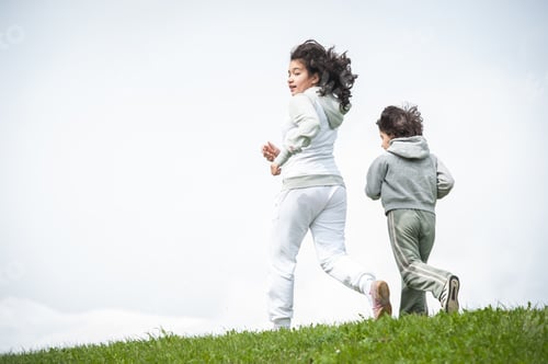 Preview: Boy And Girl Running And Jumping On Spring Field In Alps