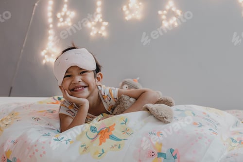 Preview: Smiling Child Relaxing in Bed with Stuffed Animal