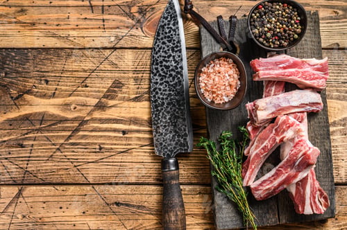 Preview: Sliced lamb short spare loin ribs, raw meat on a wooden cutting board.