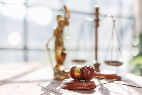 Preview: A wooden hammer, scales, legal documents and a laptop placed on the desk symbolize law, justice,