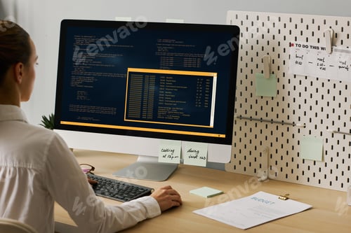 Preview: Close up young woman using computer and writing code working at desk
