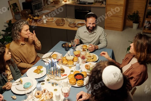 Preview: Happy family of five having chat while sitting by served table