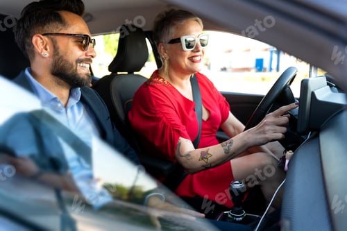 Preview: Businesswoman driving car with businessman passenger using gps navigation system