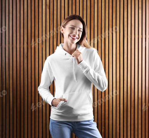 Preview: Portrait of woman in hoodie sweater on wooden background. Space for design
