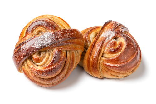 Preview: Pair of homemade fresh baked swedish cardamom bun on white background close up