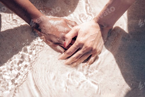 Preview: Hands of two women different ethnicity: Korean and African: one on top of the other
