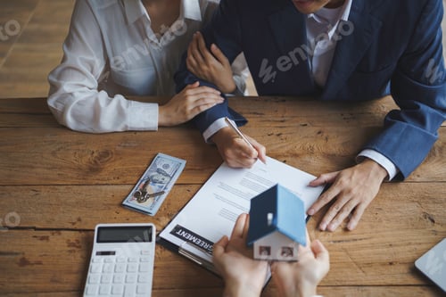 Preview: Young married couple talking to a real estate agent to sign a house purchase contract.