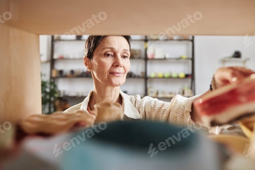 Preview: Adult woman using kiln in pottery studio