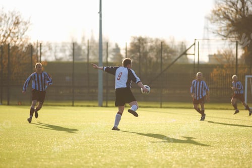 Preview: Football player kicking ball