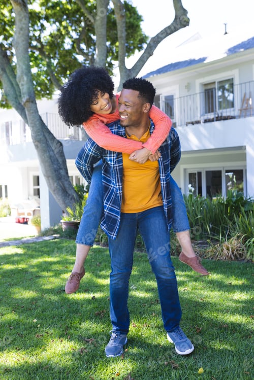 Aperçu: Happy african american couple riding piggyback in sunny garden, copy space
