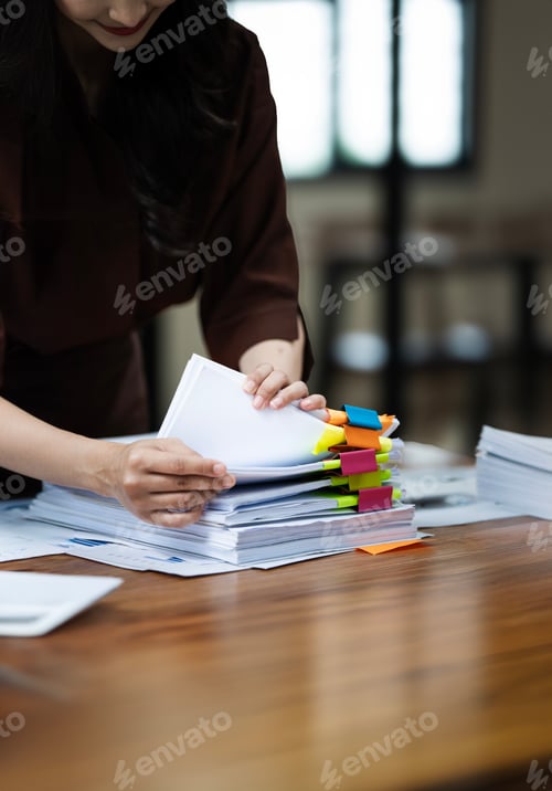 Preview: Businesswoman hands working in Stacks of paper files
