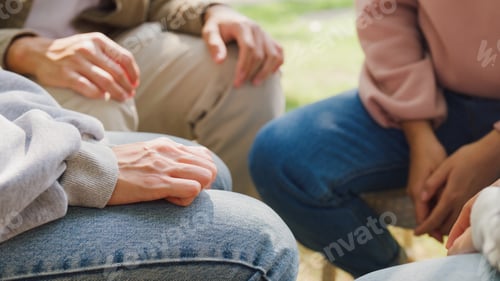 Preview: Close-up of diverse multiracial men and women group sit in circle hold hands together hope.