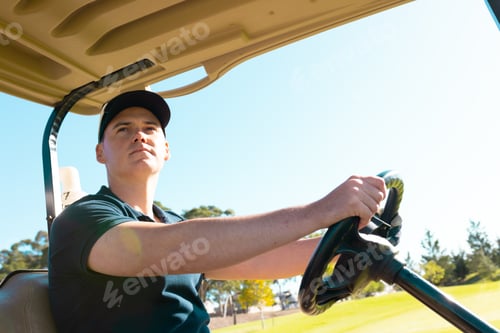 Preview: Low angle view of caucasian young man looking away while driving golf cart against clear sky