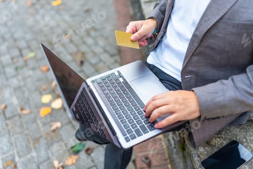 Preview: Businessman using credit card to shop online outdoors