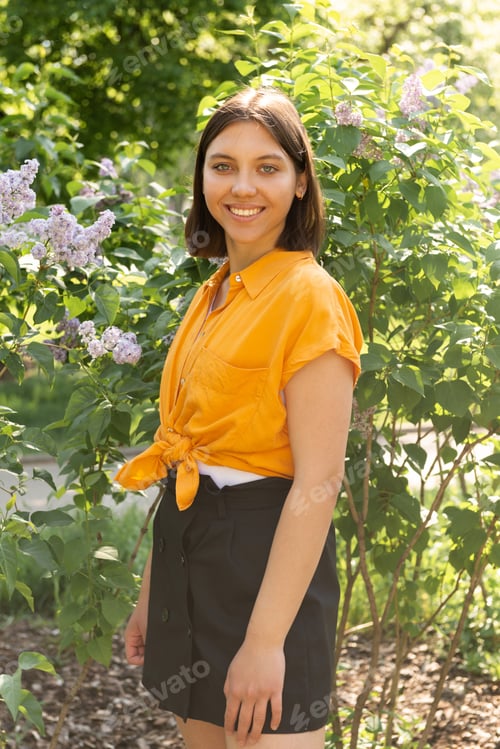 Preview: Young smiling girl portrait outdoors, posing at beautiful blooming trees at sunlight