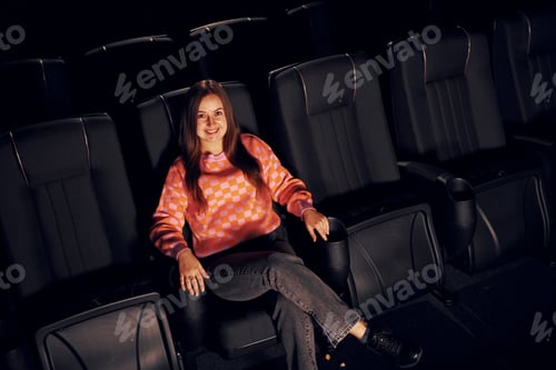 Preview: Adult woman sitting in the cinema and watching movie