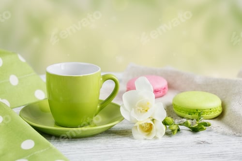 Preview: Cup of black coffee, white freesia flowers and sweet pastel french macaroons