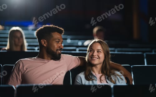 Preview: Front view of cheerful young couple in the cinema, watching film