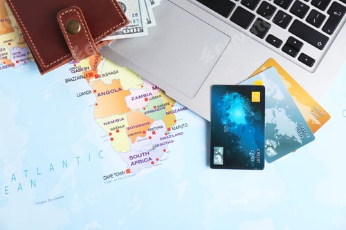 Preview: Flat lay composition with credit cards, money and laptop on map. Travel agency