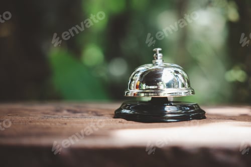 Preview: Closeup of silver service restaurant bell on wooden counter desk