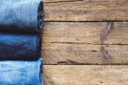 Preview: Jeans stacked on a wooden background