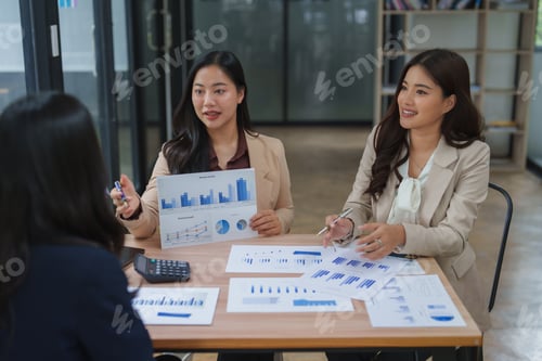 Preview: Businesswomen discussing financial charts and graphs during meeting