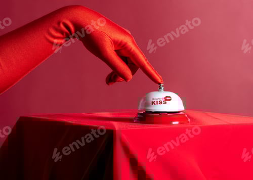 Preview: A woman's hand in a red glove presses a call bell on a red background
