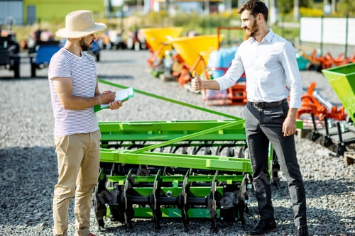 Preview: Agronomist with salesman at the shop with agricultural machinery