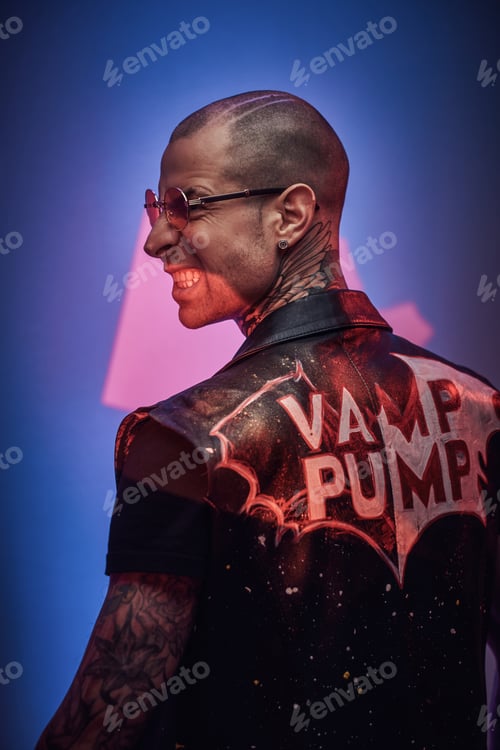 Preview: Fashionable tattooed male model posing in a studio