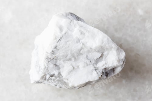 Preview: sample of raw howlite rock on white marble