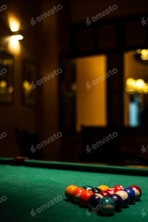 Preview: billiards balls on pool table in cozy dark bar interior