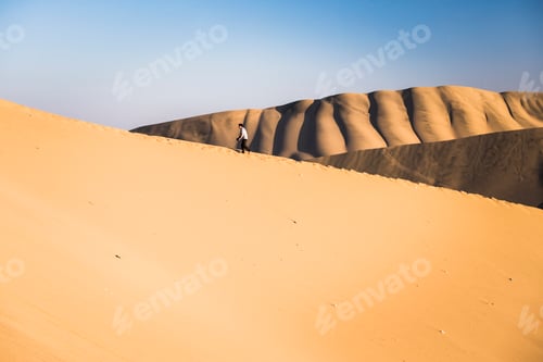 Preview: People climbing sand dunes to watch the sunset over the desert at Huacachina, Ica Region, Peru, Sout
