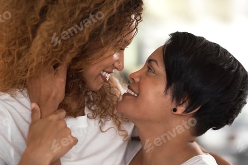 Preview: Keep calm and love who you want. Shot of a lesbian couple staring into each others eyes at home.
