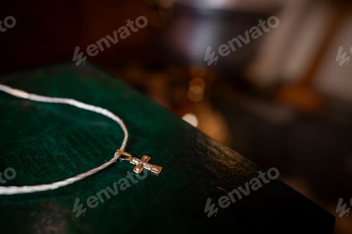 Preview: Small golden orthodox cross on white cord on green vintage book in church